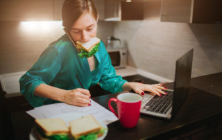 Girl with sandwhich in mouth, at computer, taking notes, Platinum Resumes, Kansas City, MO