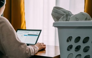 Laundry basket by woman on computer looking for a job, Platinum Resumes, Kansas City, MO