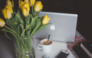 Laptop by vase of yellow tulips, Platinum Resumes, Kansas City, MO