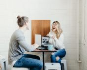 2 girls across from one another on laptops drinking coffee, Platinum Resumes, Kansas City, MO