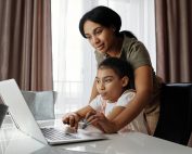 Child on laptop, mother behind helping, Platinum Resumes, Kansas City, MO