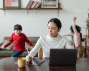 Woman working on resume at laptio with 2 kids in background, Platinum Resumes, Kansas City, MO