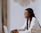 Women with long hair at laptop, smiling, Platinum Resumes, Kansas City, MO