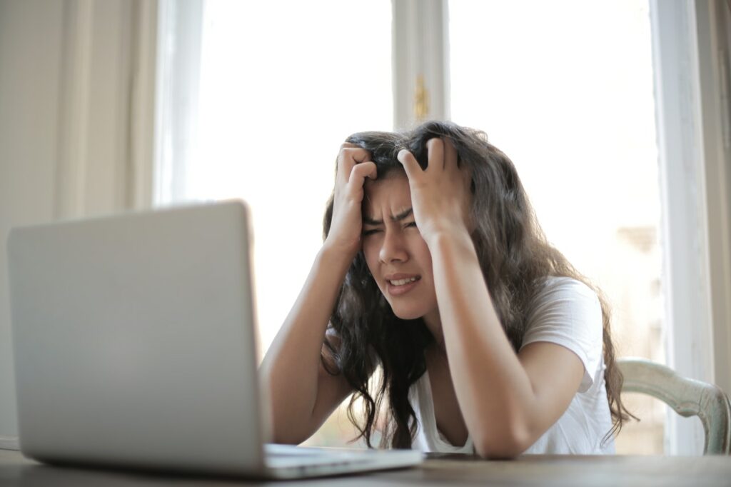 Young woman in front of her computer looking exasperated, Platinum Resumes, Kansas City, MO