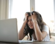 Young woman in front of her computer looking exasperated, Platinum Resumes, Kansas City, MO